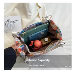Detail view of large plaid tote bag interior showing ample storage for tablet and umbrella