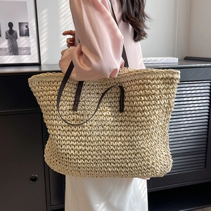 Large beige woven straw tote bag with brown leather shoulder straps for beach or commute