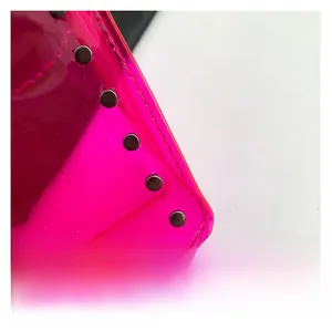 Macro shot of hot pink transparent PVC texture with silver rivets and neat stitching
