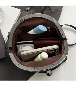 Spacious interior of black leather shell bag with zipper pocket and side slots