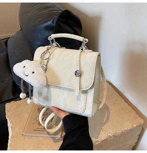 Detail of marble pattern backpack with silver twist lock and plush cloud pendant