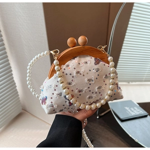 Detailed shot of white canvas bag with colorful butterfly embroidery and wood frame