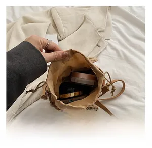 Macro view of woven straw bucket bag interior with drawstring lining and daily essentials