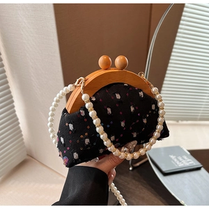 Detail of vintage sequin mini bag with wooden frame and white pearl chain strap