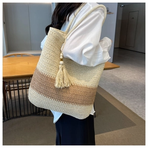 Close-up of large woven tote bag with fringe wood bead tassel for beach vacation