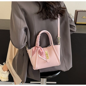 Vue détaillée du sac seau en cuir grainé rose avec poignée ornée d'un foulard en soie chic