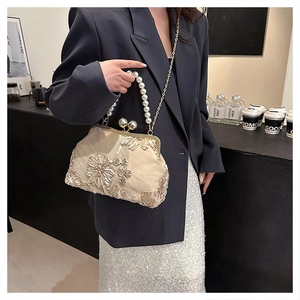Gros plan détaillé du sac vintage champagne avec broderie florale et fermoir perle