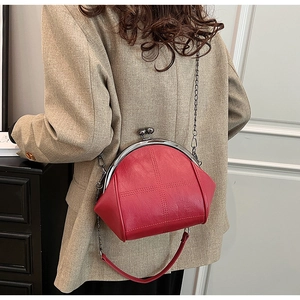 Detail of red shell bag featuring lychee texture leather and metal clasp closure