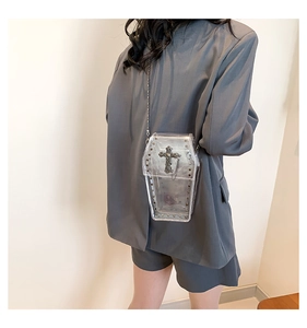 Detail of coffin-shaped transparent PVC crossbody bag with silver studs and metal cross