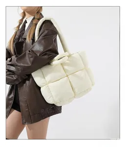 Fashionable white padded tote bag with quilted square patterns worn with a leather jacket