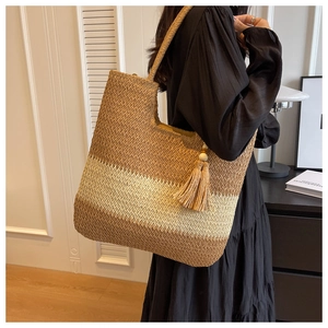 Detail of large woven straw tote with bicolor stitching and decorative wooden beads