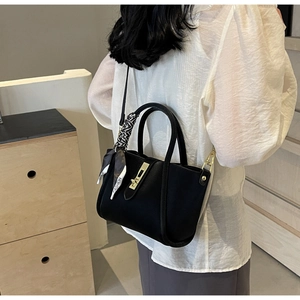 Détail du sac cabas noir en cuir grainé avec fermoir doré et foulard en soie imprimé