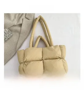 Macro shot of quilted puffer tote bag fabric texture in beige with soft padded handle