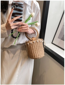 Detail of straw bucket bag with shell fringe and round handle for summer beach holidays