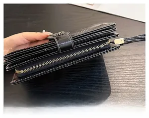 Close-up of smooth silver zipper and layered structure on black oil wax leather wallet