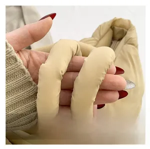 Detail of soft quilted handles on a cream padded tote bag for a comfortable grip