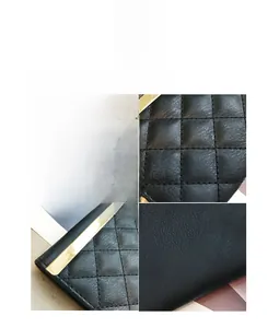 Detail of black quilted faux leather wallet with classic diamond pattern and gold trim