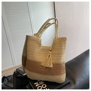 Detail of handwoven tote bag featuring three-color stripes and decorative side tassel