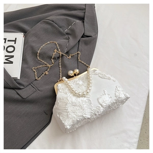 Gros plan de la broderie florale 3D sur un sac de soirée blanc avec anse en perles