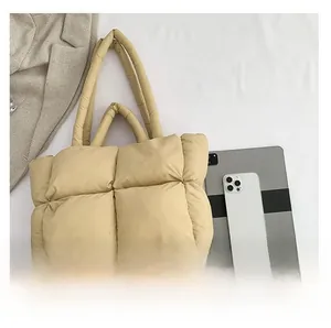 Detail view of khaki quilted puffer tote bag showing large capacity with a tablet