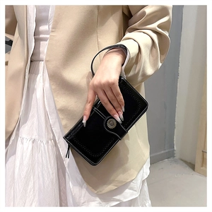 Close-up of vintage black wax leather long wallet with metal daisy buckle and wristlet strap