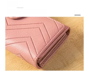 Detail of pink quilted leather wallet with uniform V-shape stitching and fine finish