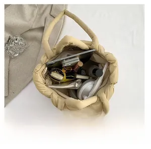 Spacious interior of beige quilted tote bag showing storage for tablet and cosmetics