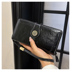 Detail of black wax leather clutch with daisy buckle and white contrast stitching