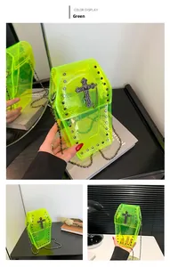 Macro view of neon green coffin shaped PVC crossbody bag with studs and metal cross