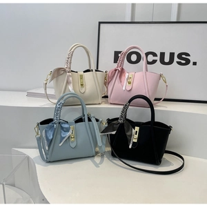 Détail de quatre sacs seau à motif litchi colorés avec foulards et boucles dorées