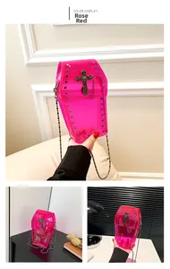 Detail of rose red coffin-shaped PVC crossbody bag with studs and metal cross decoration