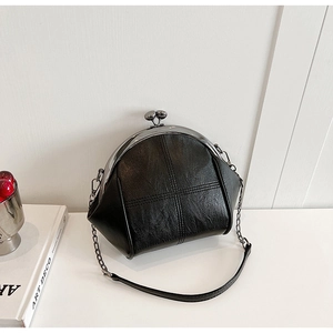 Detail of vintage black kiss-lock shell bag with cross stitching and silver metal chain