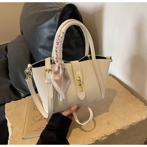 Détail du sac seau crème texturé litchi avec poignée foulard en soie et fermoir