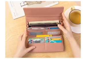 Detailed interior of a pink long wallet with multiple card slots and phone compartment