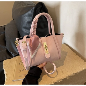 Détails du sac à main rose en cuir grainé avec fermoir doré et foulard décoratif