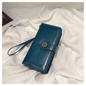 Detailed close-up of dark teal oil wax leather wallet with retro brogue patterns