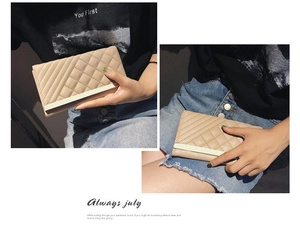 Detail of apricot quilted leather long wallet featuring a decorative light gold metal trim