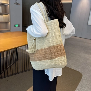 Large woven tote bag with beige and brown color-blocking and fringe tassel detail