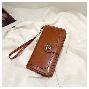 Detail of vintage oil wax leather wallet featuring a sunflower metal buckle and hand strap