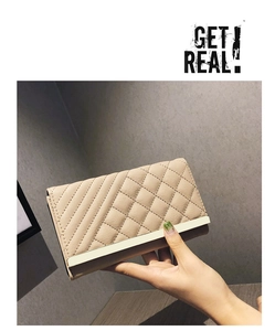 Detail of apricot quilted long wallet with elegant gold metal trim and textured finish