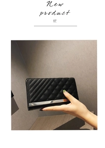 Detail showing quilted black long wallet with silver metal trim and leather texture