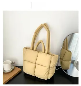 Close-up of khaki quilted down tote bag with large puffer square pattern and long handles
