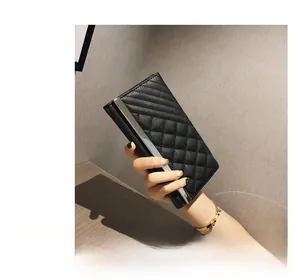 Detail of a black long wallet with quilted stitch pattern and silver metal trim