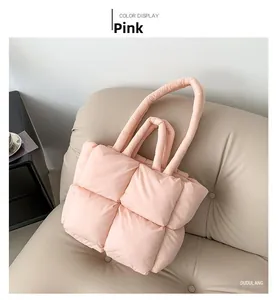 Close-up of pink quilted tote bag with puffy feather-down texture on a beige sofa