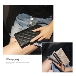 Detail of quilted leather texture and metal bar on minimalist long tri-fold clutch wallets