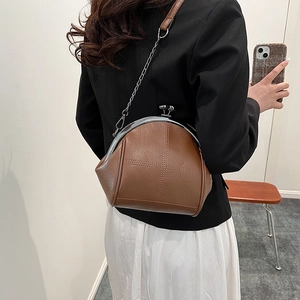 Brown retro PU leather shell bag with metal frame and chain strap shown on a model