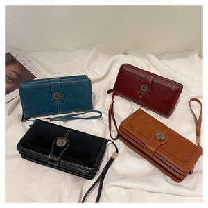 Close-up of vintage faux leather wallets with sunflower metal buckle and hand straps