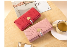 Detail of red and pink quilted leather wallets with heart-shaped metal clasps