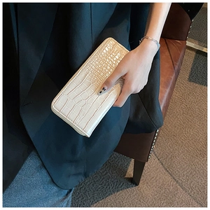 Detail of cream long wallet with crocodile embossing and premium metal zipper finish