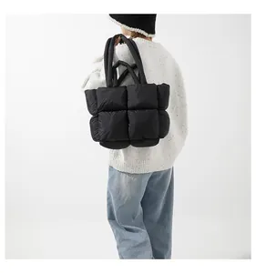 Detailed back view of a person carrying the black quilted puffer tote bag with shoulder straps